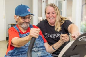 A rehab therapist with a resident in the rehab gym at Circleville Post-Acute