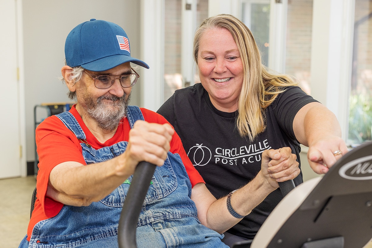 A rehab therapist with a resident in the rehab gym at Circleville Post-Acute