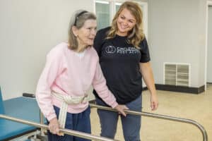 A rehab therapist helping with a resident in the rehab gym at Circleville Post-Acute