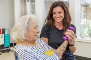 A rehab therapist helping a resident in the rehab gym at Circleville Post-Acute