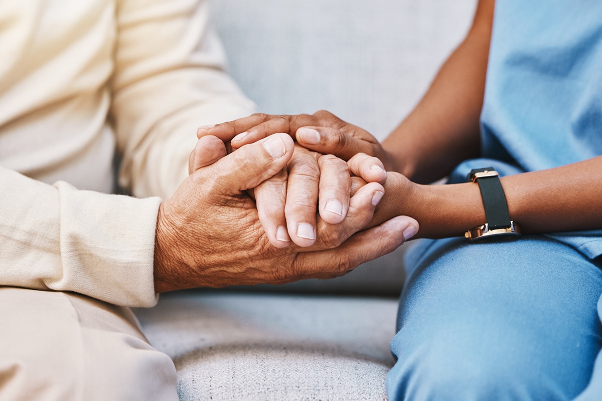 Nurse and patient holding hands for comfort